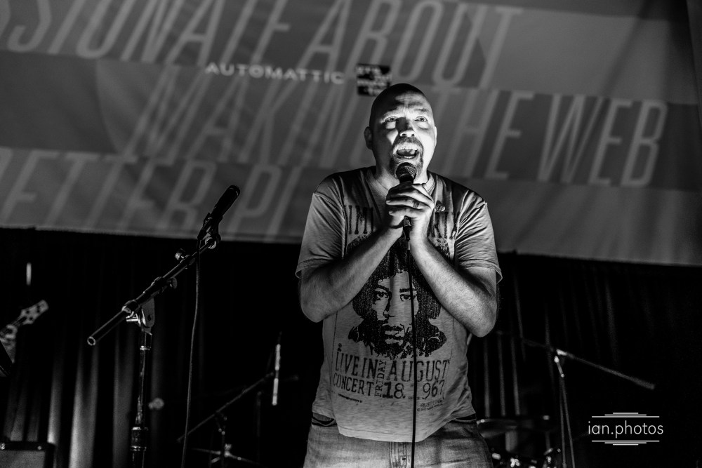 Singer on stage at a concert in black and white. 